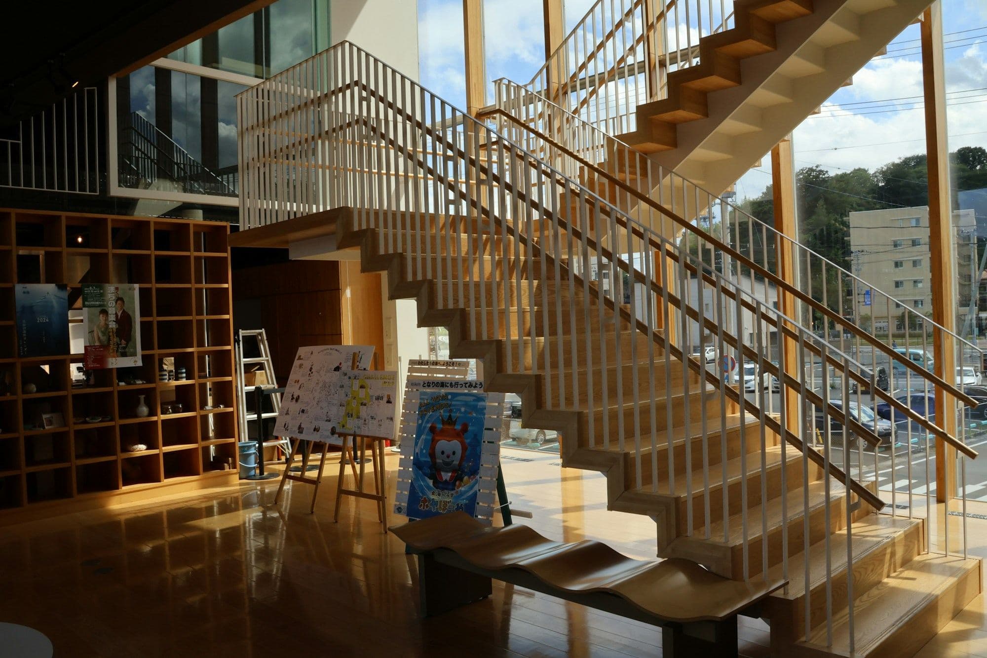 Bright shared learning space with shelves and an open staircase